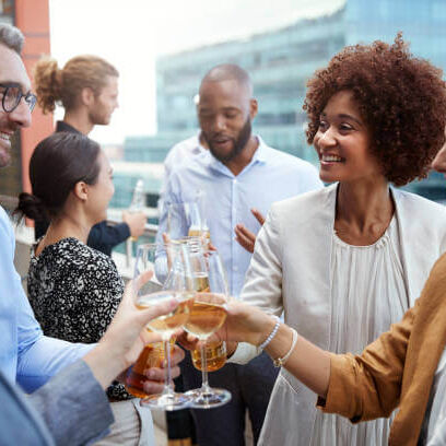 Socialising office colleagues raising glasses and making a toast with drinks after work